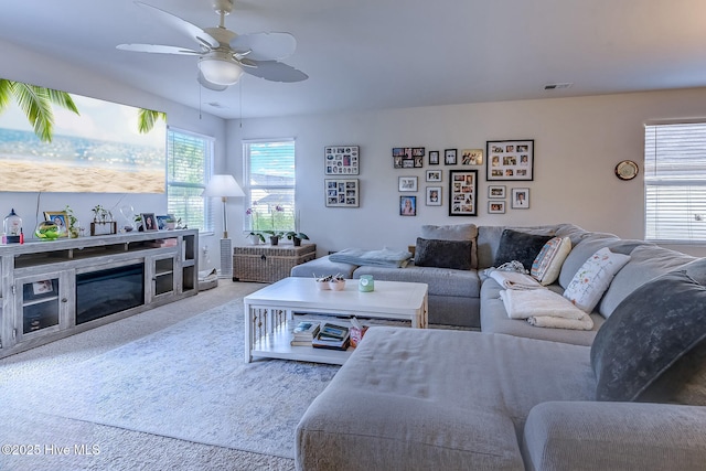 carpeted living room with ceiling fan