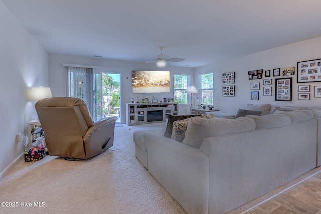 carpeted living room featuring plenty of natural light and ceiling fan