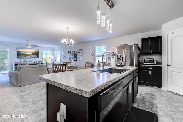 kitchen featuring sink, dishwasher, an island with sink, and decorative light fixtures