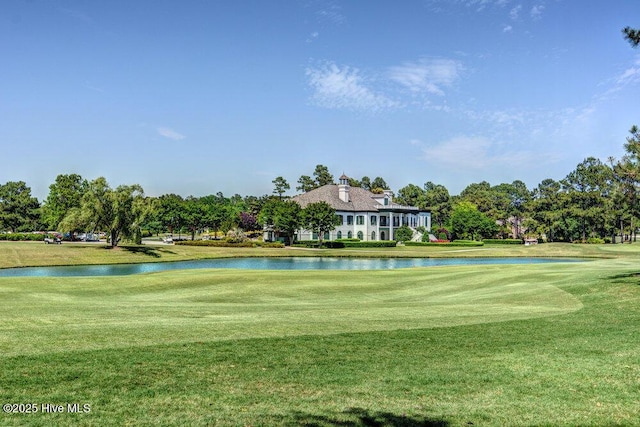 view of property's community featuring a lawn, a water view, and golf course view