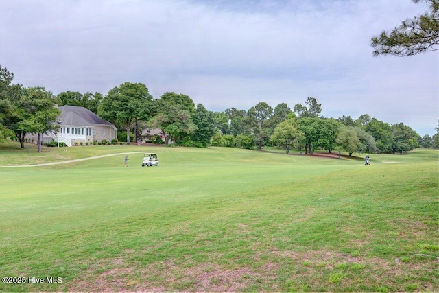 surrounding community featuring view of golf course and a yard