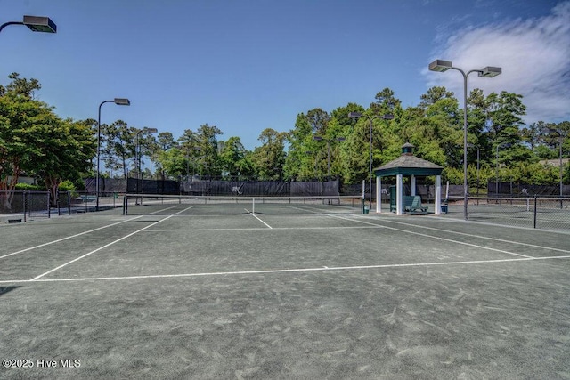 view of tennis court featuring a gazebo and fence