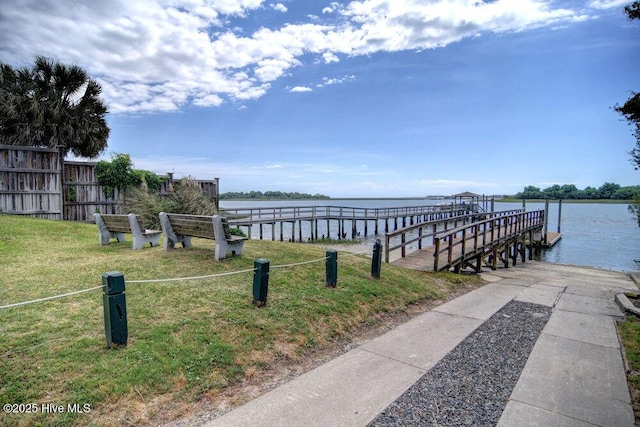 view of dock featuring a lawn and a water view