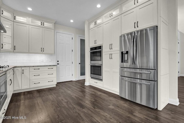 kitchen featuring dark wood-type flooring, baseboards, light stone countertops, and stainless steel appliances