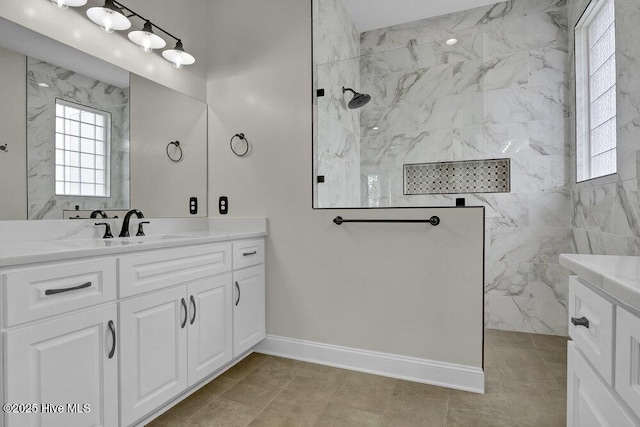 bathroom featuring a marble finish shower, baseboards, vanity, and tile patterned floors