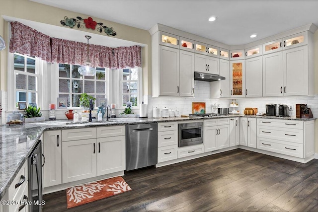 kitchen featuring stainless steel appliances, hanging light fixtures, sink, and white cabinets