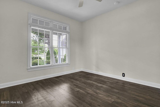 unfurnished room with a ceiling fan, baseboards, and dark wood-style floors