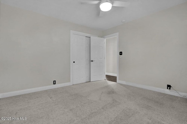 carpeted empty room with baseboards and ceiling fan