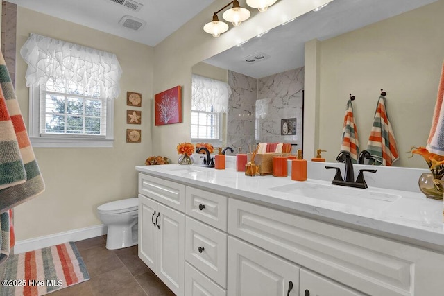 bathroom with tile patterned flooring, vanity, tiled shower, and toilet