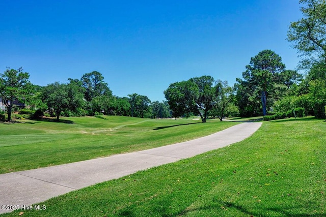 view of home's community featuring golf course view and a yard