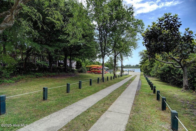 view of home's community with a water view and a yard