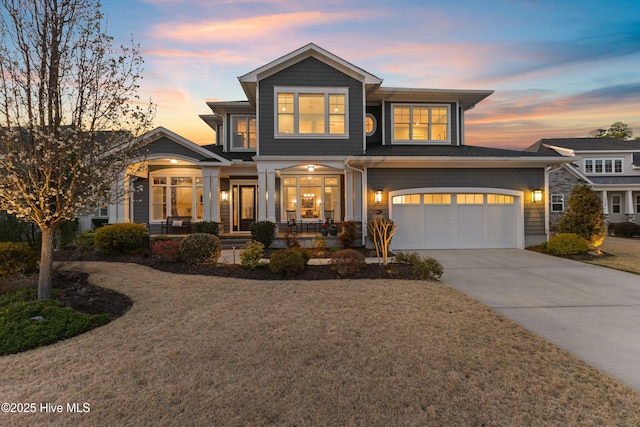 view of front facade with a porch, driveway, and an attached garage