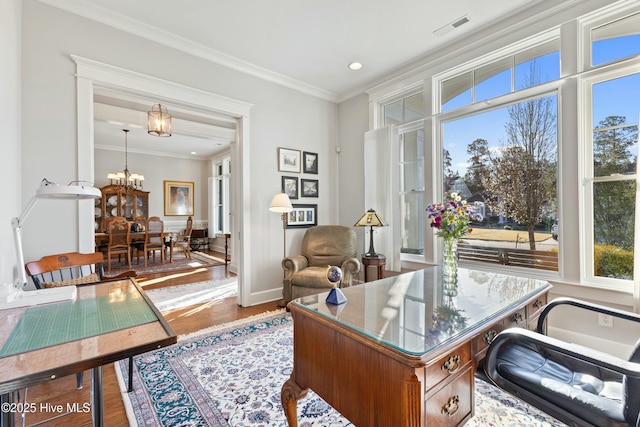 office with an inviting chandelier, crown molding, wood finished floors, and visible vents