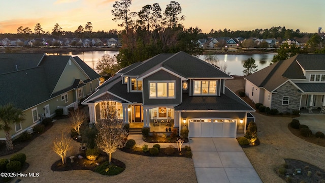 view of front facade with a residential view, a water view, an attached garage, and driveway