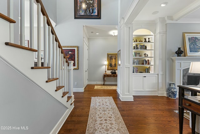 entryway with crown molding, stairs, baseboards, and wood finished floors