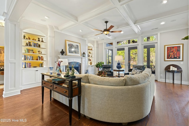 living room with a ceiling fan, beam ceiling, coffered ceiling, and a fireplace