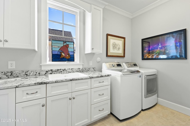 laundry room with baseboards, cabinet space, ornamental molding, a sink, and washer and dryer