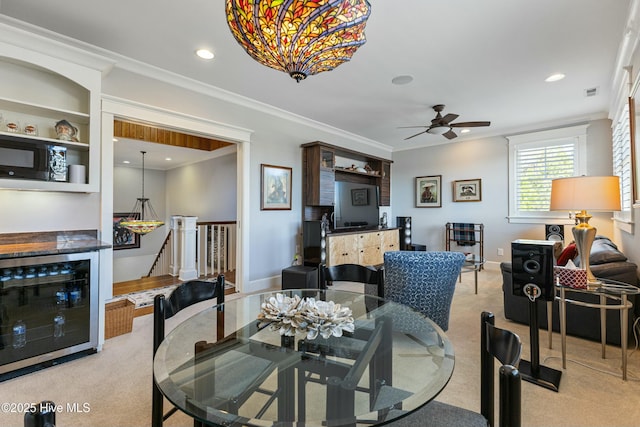 carpeted dining area with visible vents, ornamental molding, recessed lighting, wine cooler, and ceiling fan