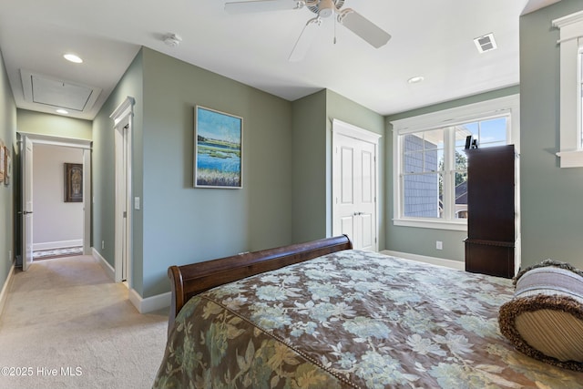 carpeted bedroom with visible vents, a ceiling fan, a closet, baseboards, and attic access