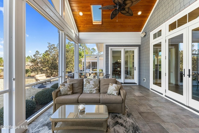 sunroom / solarium with vaulted ceiling with skylight, wood ceiling, and a ceiling fan