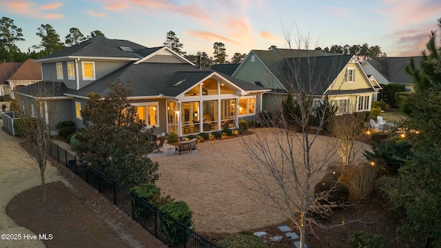 rear view of property with a patio, a sunroom, and fence