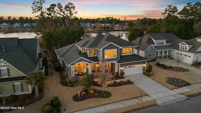 view of front of home featuring a water view, an attached garage, a residential view, and driveway