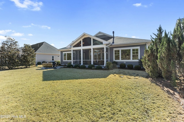 rear view of house with a lawn and a sunroom