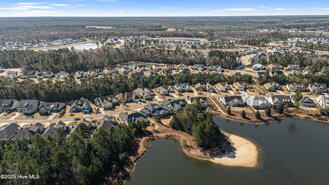 aerial view featuring a wooded view, a water view, and a residential view