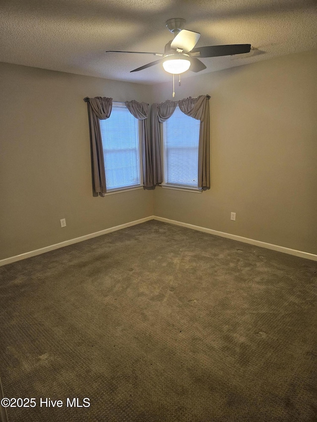 empty room featuring dark carpet, ceiling fan, and a textured ceiling