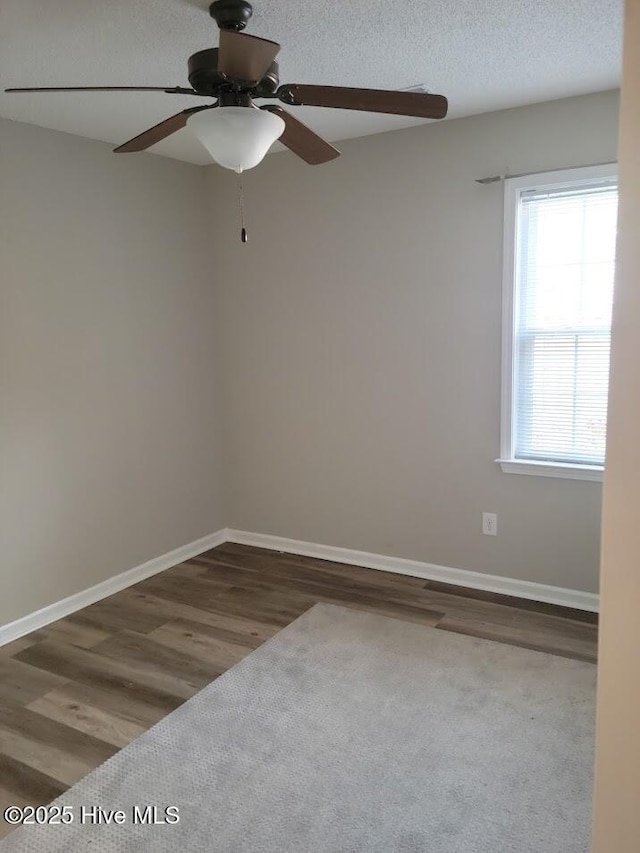 empty room with a textured ceiling, hardwood / wood-style floors, and ceiling fan