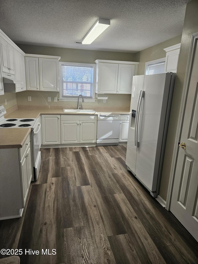 kitchen featuring white appliances, sink, a textured ceiling, dark wood-type flooring, and white cabinets