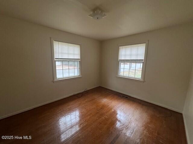 spare room with dark hardwood / wood-style floors