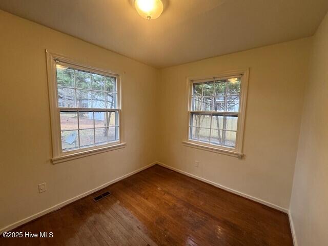 empty room with dark hardwood / wood-style flooring