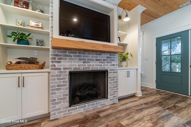 living room with hardwood / wood-style flooring, wooden ceiling, a fireplace, and built in shelves