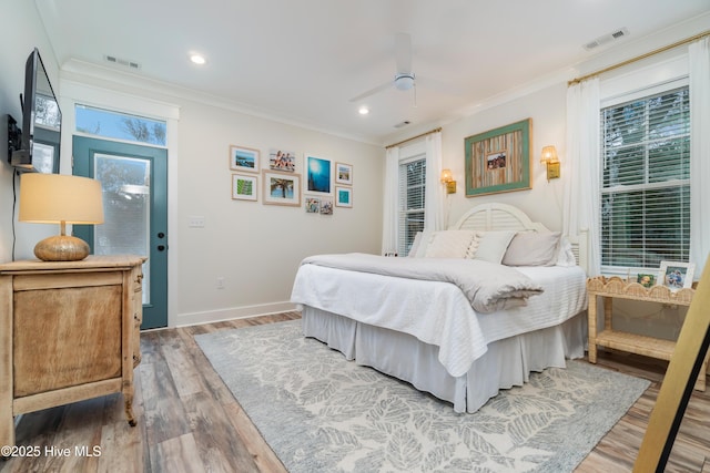 bedroom with hardwood / wood-style flooring, ornamental molding, and ceiling fan