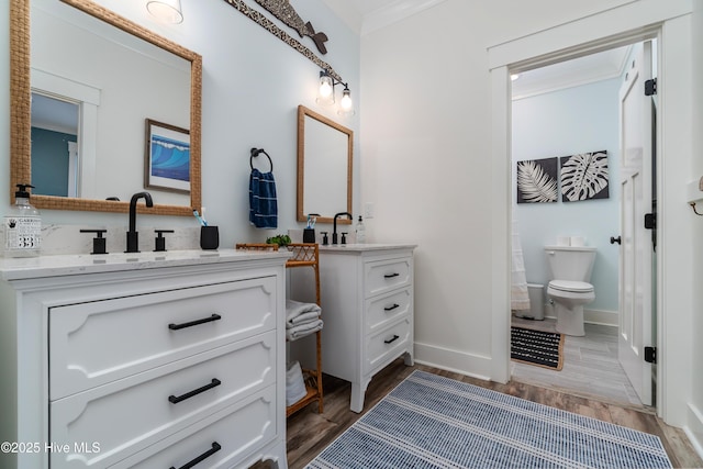 bathroom featuring vanity, hardwood / wood-style flooring, crown molding, and toilet