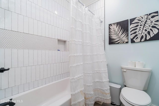 bathroom featuring shower / tub combo with curtain and toilet