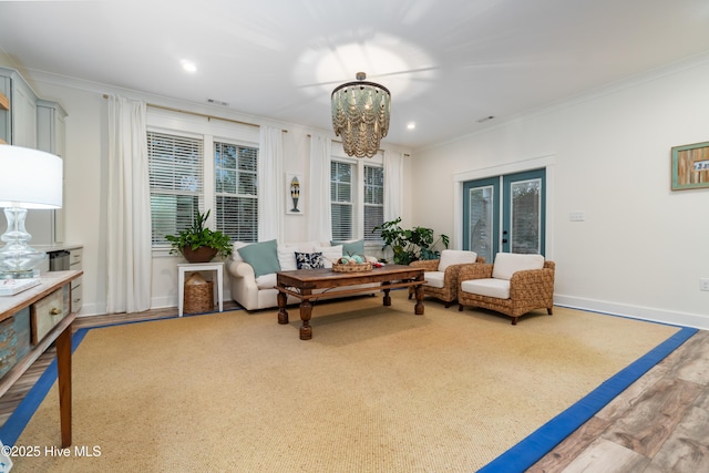 sitting room with crown molding, wood-type flooring, a chandelier, and french doors