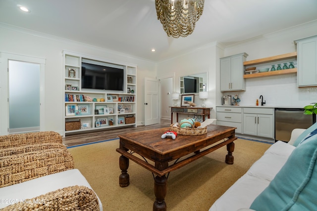 living room with ornamental molding, wet bar, a notable chandelier, and light hardwood / wood-style floors