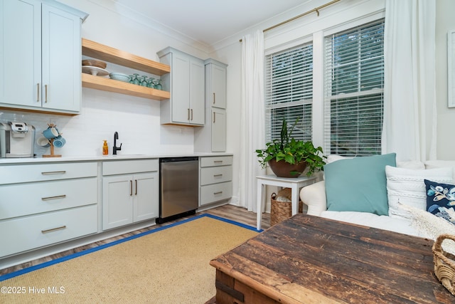 kitchen featuring dishwasher, butcher block counters, sink, decorative backsplash, and ornamental molding