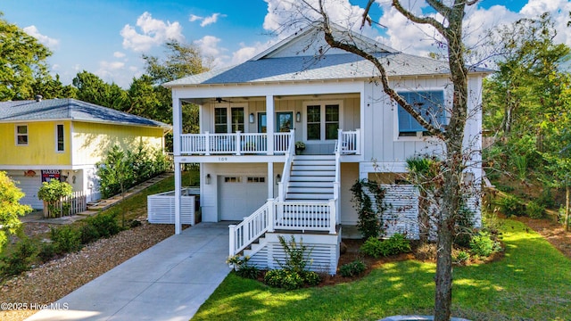 coastal home featuring a garage, a front yard, and covered porch