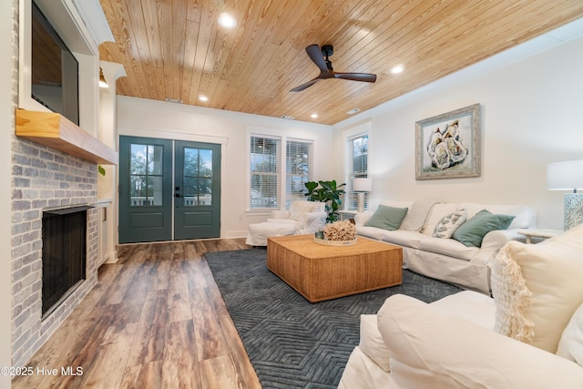 living room with dark hardwood / wood-style floors, a fireplace, ceiling fan, wooden ceiling, and french doors