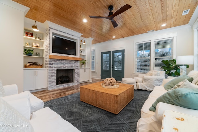 living room featuring wood ceiling, crown molding, and french doors