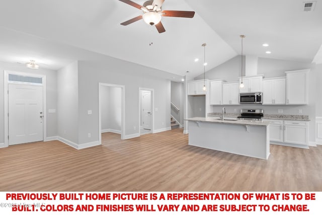 11 Pine Shore Dr, Southport, NC 28461 - kitchen with stainless steel appliances, a sink, white cabinets, a ceiling fan, and a kitchen bar