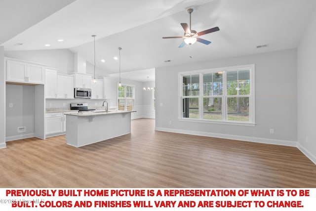 11 Pine Shore Dr, Southport, NC 28461 - kitchen featuring stainless steel appliances, a sink, open floor plan, white cabinets, and a ceiling fan