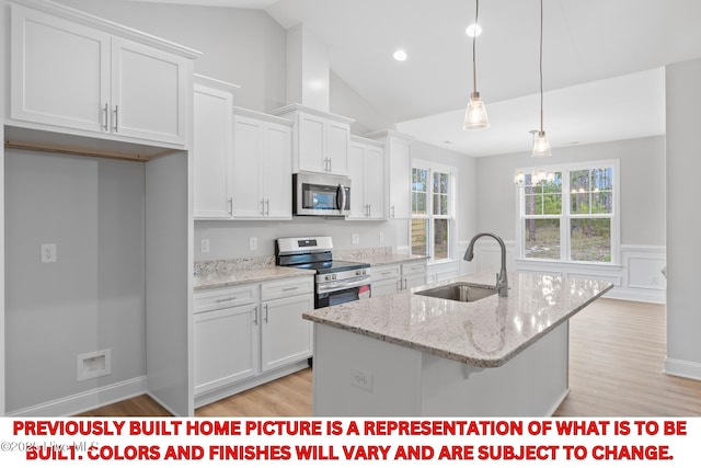 11 Pine Shore Dr, Southport, NC 28461 - kitchen with appliances with stainless steel finishes, a sink, white cabinetry, a center island with sink, and light wood-style floors