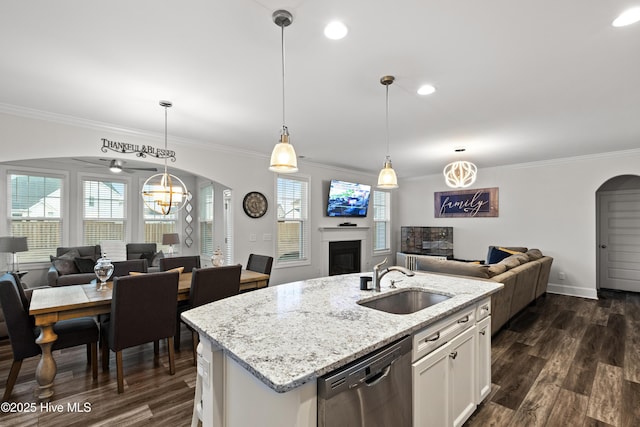 kitchen with sink, hanging light fixtures, dishwasher, a kitchen island with sink, and white cabinets