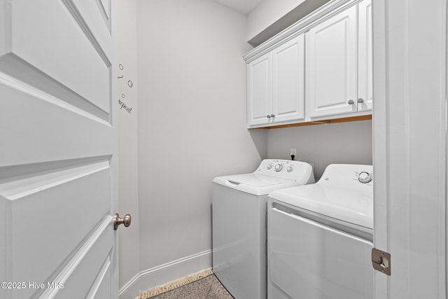 clothes washing area featuring cabinets and separate washer and dryer