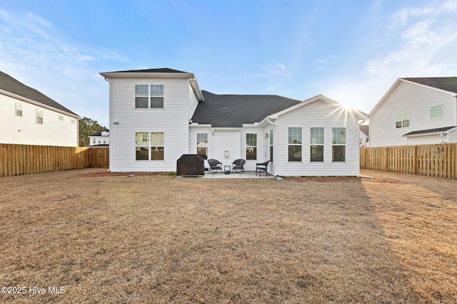 rear view of house with a lawn and a patio