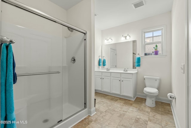 full bathroom featuring a sink, double vanity, a shower stall, and visible vents